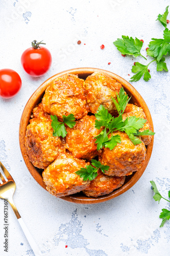 Meatballs with tomato sauce in bowl on white table background. Top view