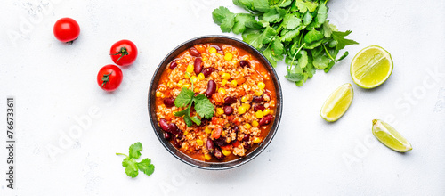 Chili con carne, mexican dish with minced beef, red beans, paprika, corn and hot peppers in spicy tomato sauce, tex-mex cuisine, white background, top view banner