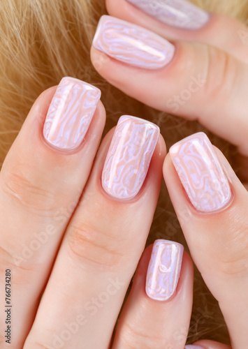 hand with shiny pink and white marble gel manicure