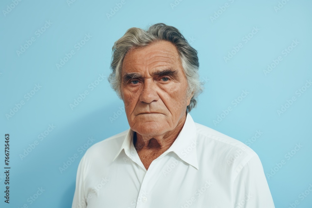 Portrait of a senior man looking at camera against blue background. Portrait of a senior man looking at camera against blue background.