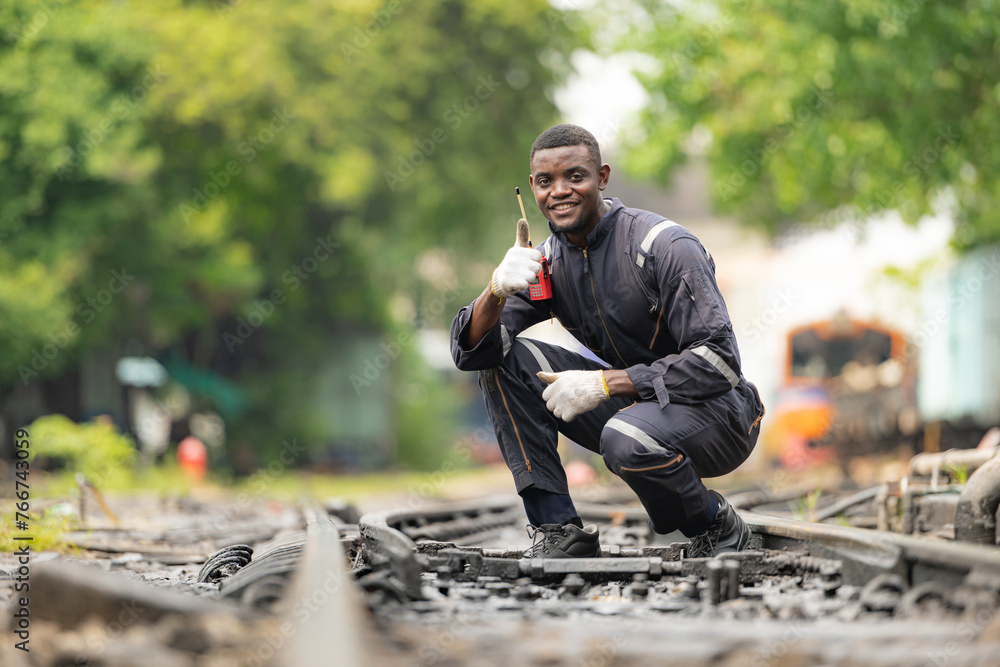 Fototapeta premium Portrait of a railway engineer on the tracks of a train in station platform.