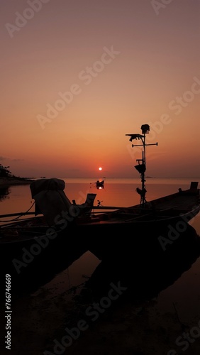 In the tranquil ambiance of Ko Pha Ngan, Thailand, the island's silhouette dances against the twilight sky, casting mesmerizing shadows over the sea as the sun sets in a breathtaking display of orange