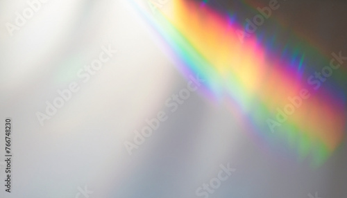 Blurred rainbow light refraction texture overlay effect for photo and mockups. Organic drop diagonal holographic flare on a white wall. Shadows for natural light effects
