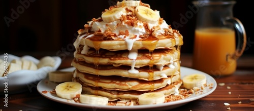 A delicious dish of fluffy pancakes stacked high, topped with slices of ripe bananas and drizzled with sweet syrup on a plate