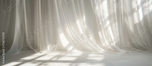 Light and shadows create lines on the curtain and cast silhouettes on the white wall on a sunny day with the sun's rays, providing a mockup with space for text.