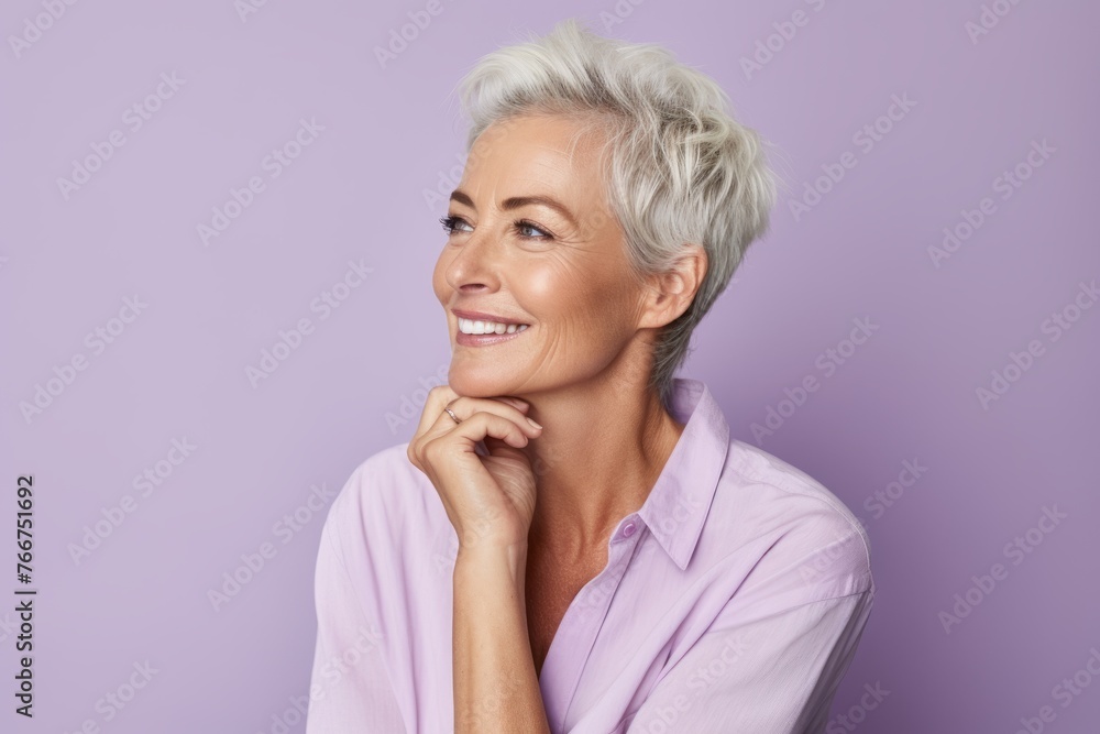 Smiling middle aged woman with short hair looking away over purple background Smiling middle aged woman with short hair looking away over purple background