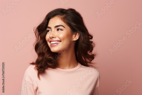 Portrait of beautiful young happy smiling woman, over pink background.