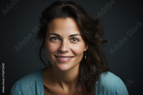 Portrait of a beautiful young woman smiling on a dark background.