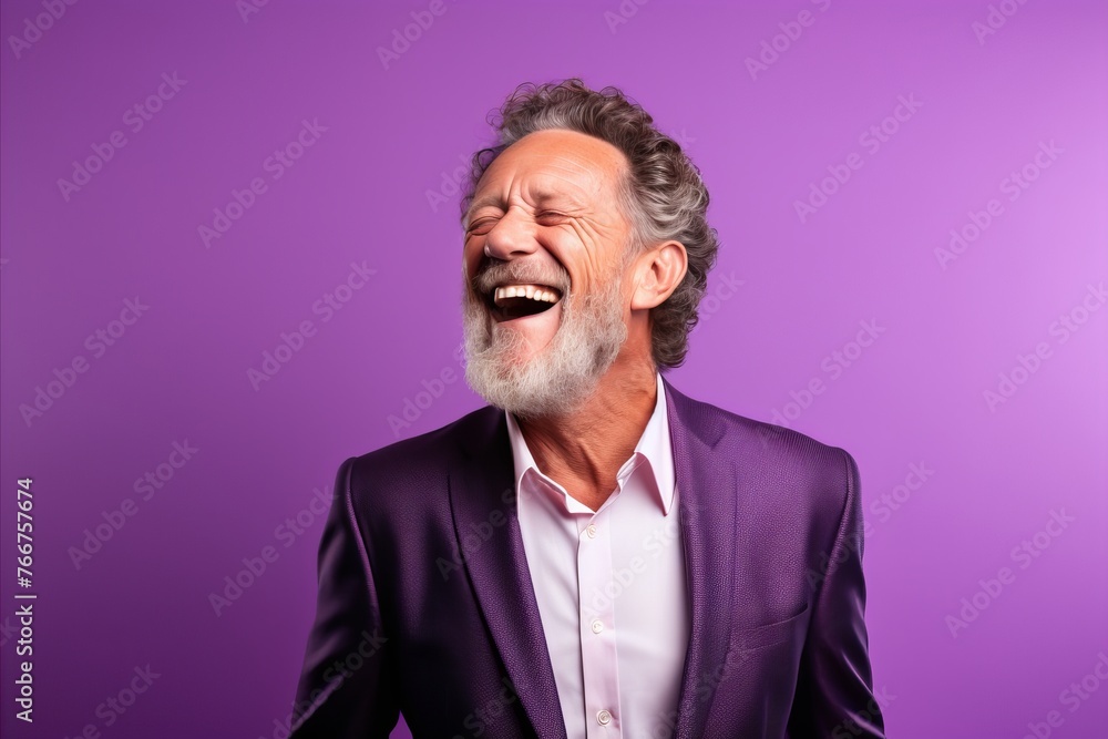 Handsome senior man with grey hair and beard laughing against purple background Handsome senior man with grey hair and beard laughing against purple background