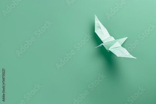 origami Bird on pastel green background photo