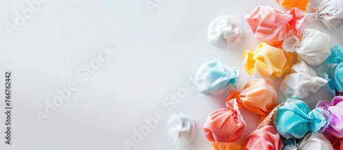 Colorful salt water taffy on a white backdrop with space for text. A close-up shot with a very blurry background.