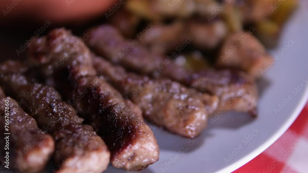 Grilled Lula kebab on skewer on grill, barbecue, potatoes wedges, sweet pepper, hot cast iron grate. Close up. High quality 4k footage Grilled Lula kebab on skewer on grill, barbecue, potatoes wedges, sweet pepper, hot cast iron grate. Close up. High quality 4k footage
