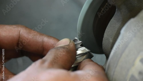 Close up scene manual tool regrind process with the abrasive wheel.