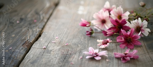 Flowers displayed on a weathered wooden table, creating a textured background with space for text.