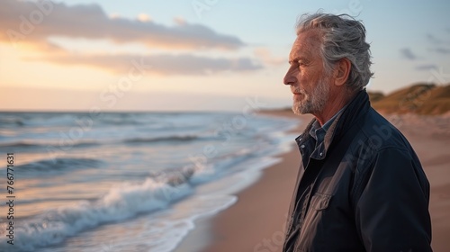 A man stands on the sandy beach next to the vast ocean © Viktor