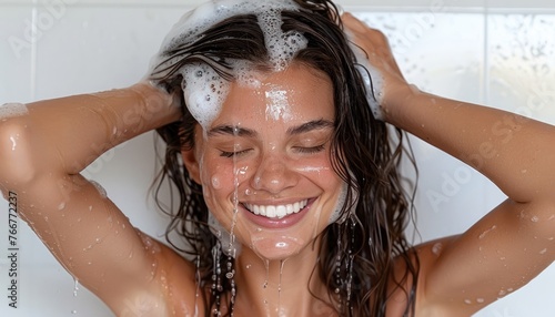 A happy woman washes her hair with a smile on her face