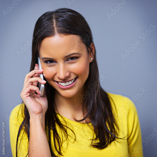 Woman, phone call and contact in studio with portrait for conversation, talk and listen by blue background. Girl, person and model on smartphone, smile or communication with mobile network in Mexico