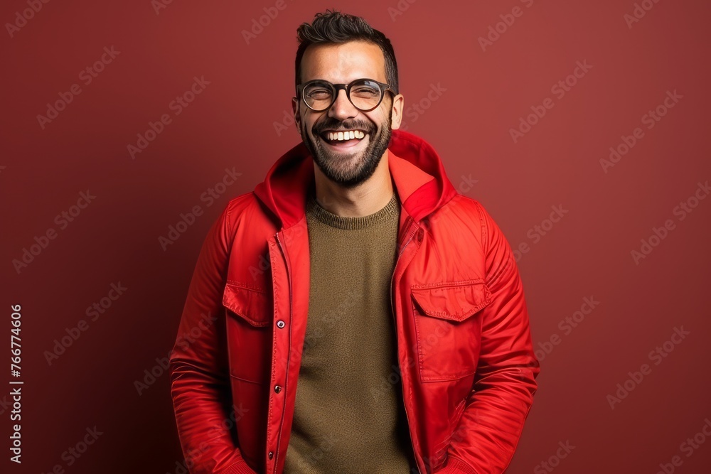 Handsome man wearing a red jacket and glasses on a burgundy background Handsome man wearing a red jacket and glasses on a burgundy background