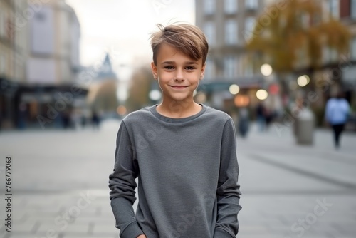 Portrait of a cute young boy standing in the street and smiling