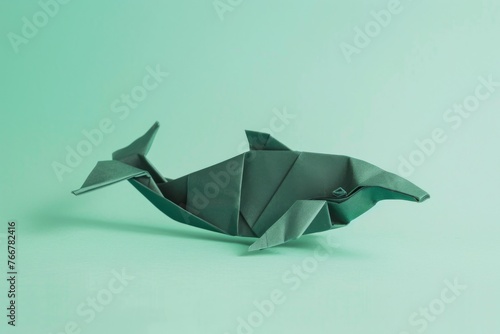 origami whale on pastel green background