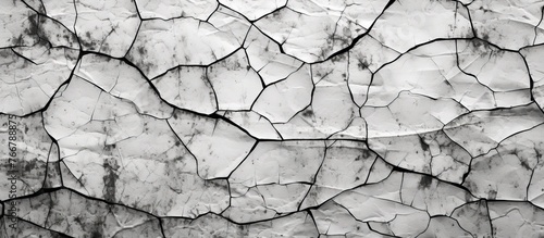 A close-up view of a weathered cracked wall displaying a black and white vintage photograph