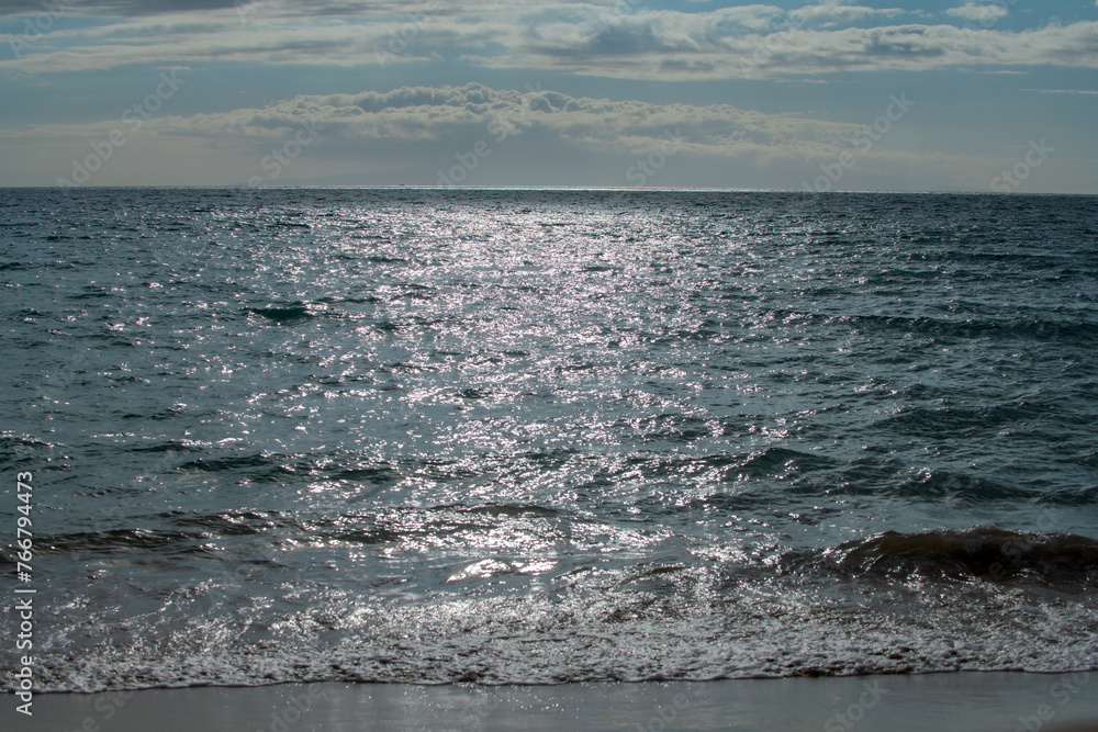 Fototapeta premium Sea abstract or rippled water texture background. Calm water surface texture with splashes and waves. Abstract nature background. Surface of blue ocean water.