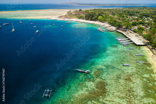 Boats surrounding a coral reef and small tropical island