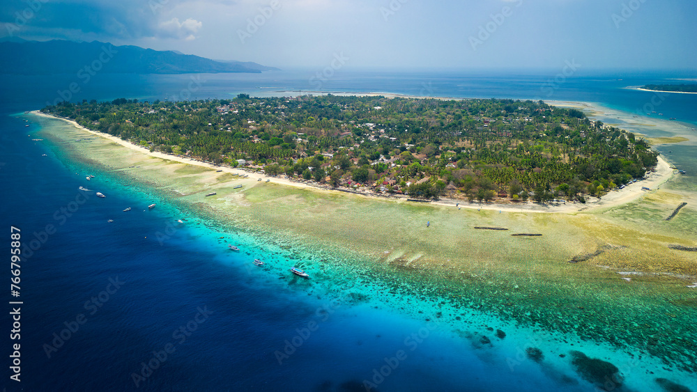 Aerial view of fringing coral reef surrounding a small tropical island in a warm ocean (Gili Air, Indonesia)