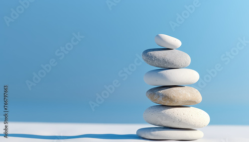 Balancing white stones on blue background