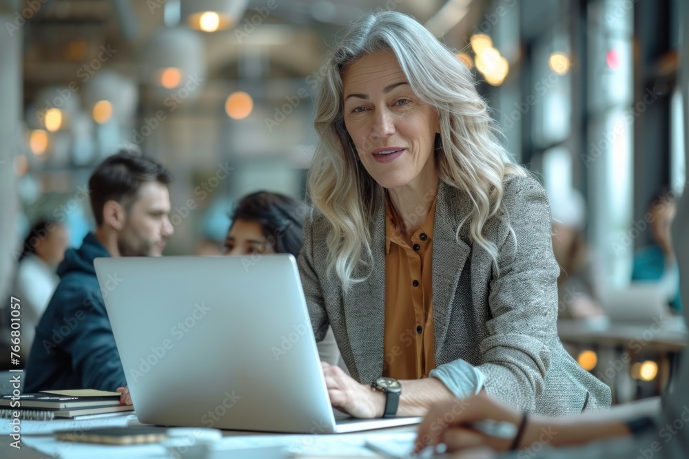 Businesswoman focused on laptop, working diligently in modern corporate office. Businesswoman focused on laptop, working diligently in modern corporate office.