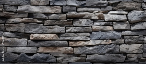 A detailed view of a sturdy stone wall with a prominent fire hydrant in the middle, adding a contrast to the rough texture and color of the wall