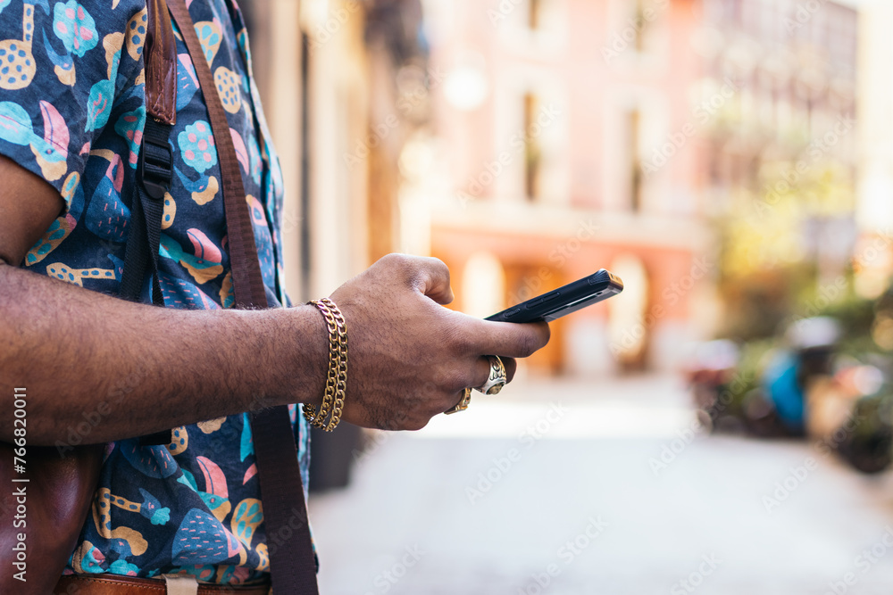 Stylish black man using smartphone outdoors in the city Stylish black man using smartphone outdoors in the city