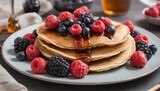 Pancakes with fresh berries and maple syrup on a plate