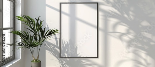 Minimalist frame mockup poster hanging on a white wall  illuminated by sunlight. The poster is in a 70x100 frame with a wall background showing window light and shadow.