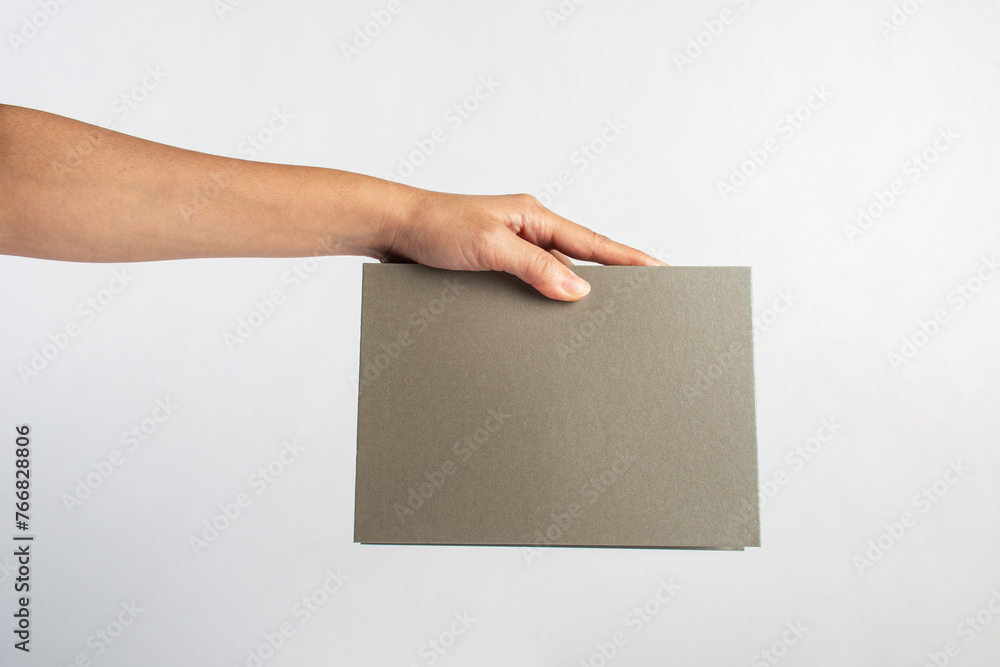 Blank grey book cover in hand on white background. Blank grey book cover in hand on white background.