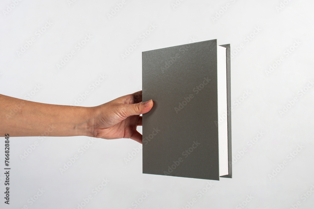 Blank grey book cover in hand on white background. Blank grey book cover in hand on white background.