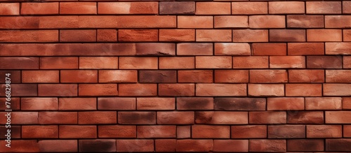 Old and worn, a brick wall displays numerous brown bricks in various shades and sizes, creating a rustic appearance