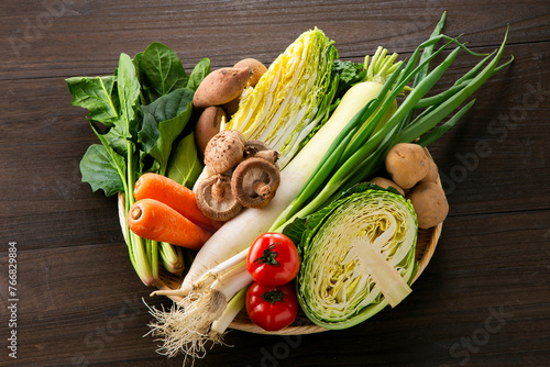 カゴに入ったキャベツ白菜大根トマトなどの野菜盛り photo