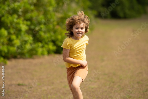 Excited Kid running in street. Amazed child enjoy run. Happy little boy running on street. Blonde cute kid run on neighborhood running road. Child boy running in park sports and run exercise for kids. © Volodymyr