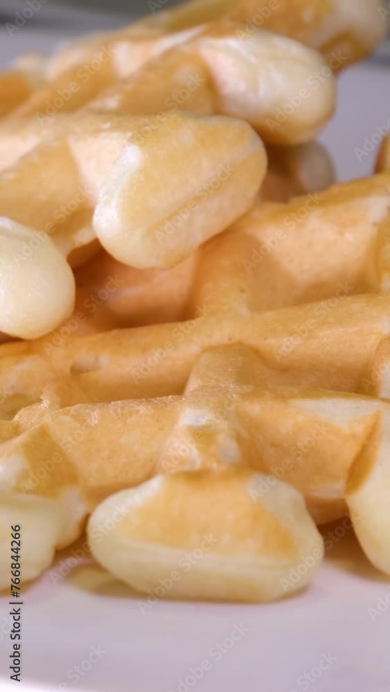 Belgian waffles in a white plate on a light wooden background. Waffles without filling. High quality 4k footage Belgian waffles in a white plate on a light wooden background. Waffles without filling. High quality 4k footage