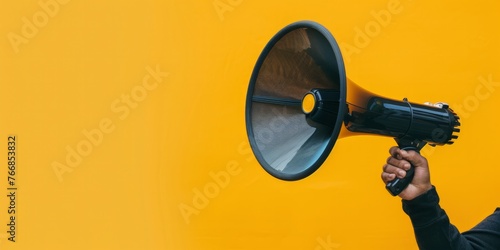 Bold Hand Holding Loudspeaker with Call to Action on Vibrant Yellow Background