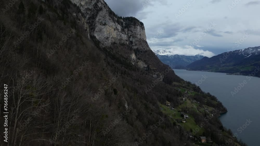 Forward drone shot of snow covered mountains with lake flowing by in Walensee, Switzerland Forward drone shot of snow covered mountains with lake flowing by in Walensee, Switzerland