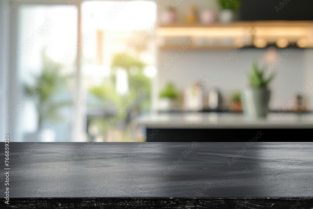The sleek black surface of a modern kitchen table stands out against the blurred background of a bright and airy kitchen space with green plants The sleek black surface of a modern kitchen table stands out against the blurred background of a bright and airy kitchen space with green plants