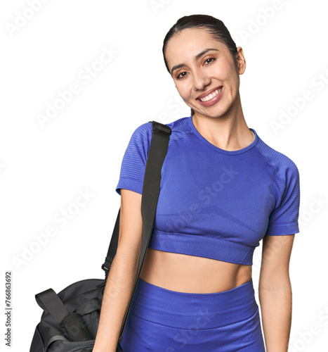 Athletic Caucasian young woman with gym bag on studio background happy, smiling and cheerful.