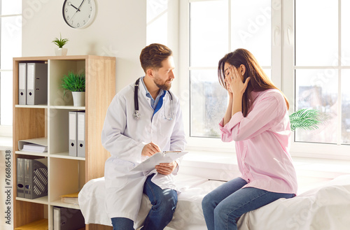 Woman patient suffering from headache or migraine consults with a doctor or nurse during a medical consultation in the hospital. The physician provides advice and treatment options for pain relief.