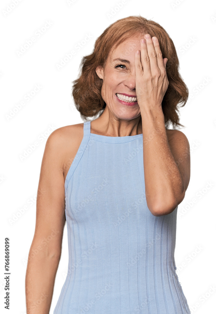 Redhead mid-aged Caucasian woman in studio having fun covering half of face with palm. Redhead mid-aged Caucasian woman in studio having fun covering half of face with palm.