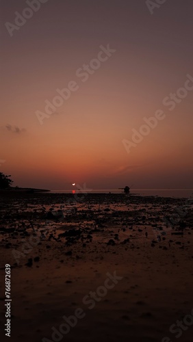 People silhouette are experiencing pure joy as they gather on the beach, delighting in the mesmerizing sunset.