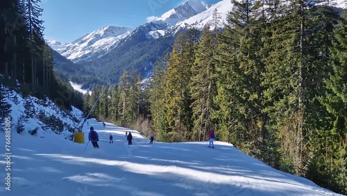 Winter season at Bansko ski resort in Bulgaria with a view to the skiers having fun on the slope and Pirin mountains in the background photo