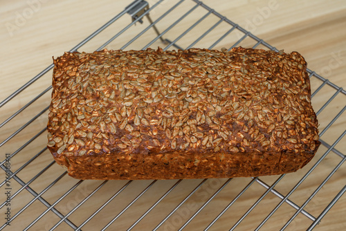 Goracy chleb z formy z ziaren studzi się na metalowej kratce