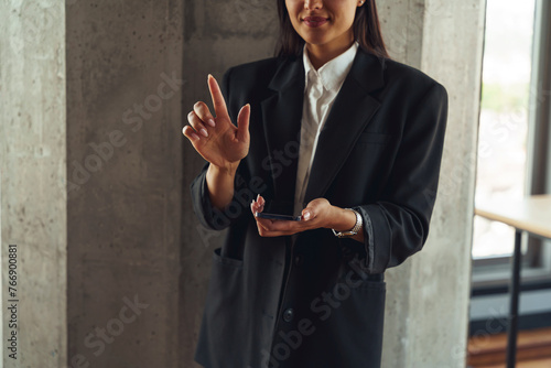 a woman in a suit is holding a cell phone in her hand